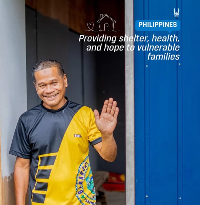 Man waving outside a shelter in the Philippines